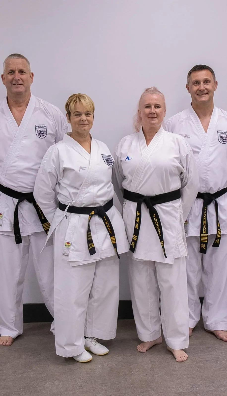 Four SDKA black belt instructors standing together against a white wall